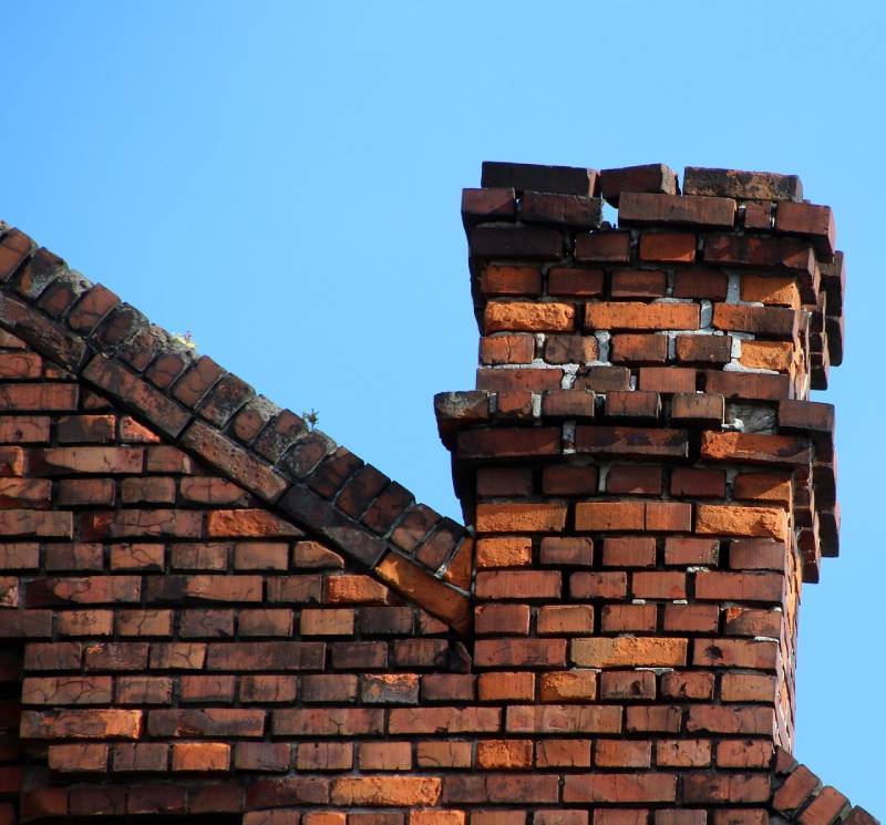 Damaged chimney on an New Carrollton home showing cracks and missing mortar